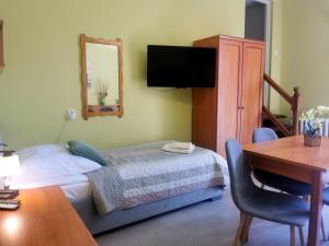 a bedroom with a bed and a desk and a mirror at Pokoje i Apartamenty SOL in Grzybowo