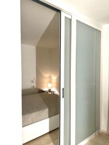 a bedroom with a bed and a sliding glass door at Only One Piccolo Pevero in Arzachena