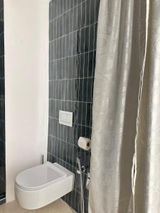 a bathroom with a toilet and a shower curtain at Only One Piccolo Pevero in Arzachena +7 photos