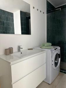 a bathroom with a washing machine and a sink at Only One Piccolo Pevero in Arzachena