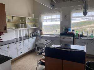 a large kitchen with white cabinets and a sink at Vestmannsvatn Guesthouse in Aðaldalur