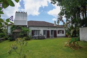 a white house with a yard with a lawn sidx sidx sidx at Casa da Igreja Velha in Furnas
