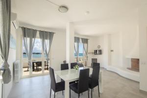 a dining room with a white table and chairs at Appartamenti vista Mare in Porto Cesareo