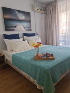 Aglaya 2 - Pomorie Bay في بوموري: غرفة نوم بسرير مع صينية عليها ورد
