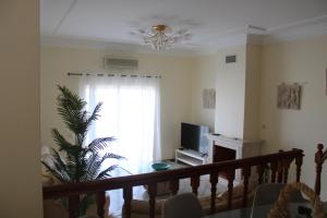 sala de estar con lámpara de araña y ventana en CountrySide Villa, en São Brás de Alportel