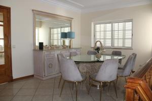Un comedor con una mesa y sillas y un espejo. en CountrySide Villa, en São Brás de Alportel