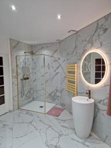 a bathroom with a marble shower and a sink at Maison Chic avec jacuzzi. UrbanSpa60 in Nogent-sur-Oise