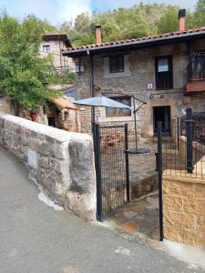 an old stone house with an open gate at "Apartamento Peña Sagra" in San Mamés