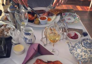 - une table avec des assiettes de nourriture et des verres de vin dans l'établissement Broadoaks Boutique Country House, à Windermere