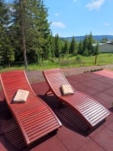 dois bancos de madeira sentados em cima de um pátio em Chechar Inn Zlatar em Nova Varos