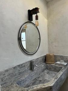 a bathroom with a sink and a mirror at La maison des Dames Marie in Coursan +4 photos
