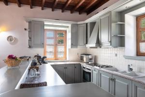 a kitchen with gray cabinets and a sink at Blue Vista Patmos in Skala +156 photos
