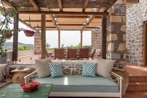 a porch with a white wicker couch on a patio at Blue Vista Patmos in Skala