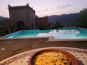 a bowl of food sitting on a table next to a swimming pool at Chambre d'hôtes aya in Ouzoud