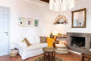 a living room with a white couch and a fireplace at Blue Vista Patmos in Skala