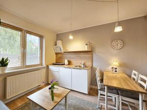 a kitchen and dining room with a wooden table at Apartament Garden- parking, ogródek, cicha okolica in Pruszcz Gdański