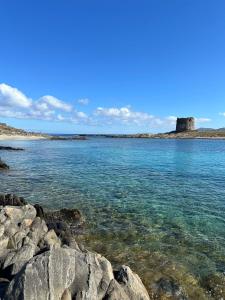 a large body of water with rocks in the foreground at Stintino vista mare l'ancora in Stintino