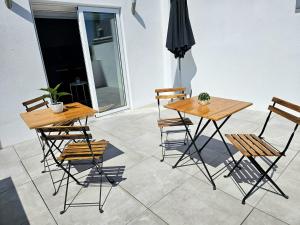 a pair of tables and chairs on a patio at Fascinante Orbita Apartments in Vila Nova de Famalicão