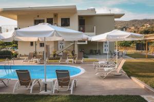 a villa with a swimming pool and chairs and umbrellas at Tsanis Estate in Parga
