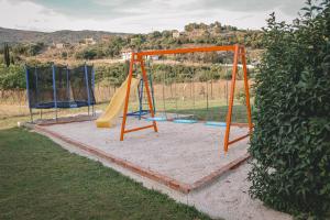 a playground with an orange and blue slide at Tsanis Estate in Parga