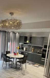 cocina con mesa, sillas y lámpara de araña en Gorgeous 2 bedrooms holiday apartement, en Niza