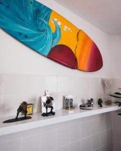 a surfboard hanging on a wall above a shelf at Costanova Surfhouse in Ílhavo