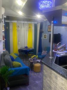 ein Wohnzimmer mit blauen Sofas und eine Küche in der Unterkunft Dea Apartments in Batumi