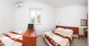 Postel nebo postele na pokoji v ubytování Apartments & Rooms Konoba Tomić