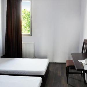 Habitación con cama, mesa y ventana en Hotel Grand, en Nizhnyaya Alekseyevka