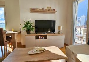 a living room with a flat screen tv and a table at Blanc in Podgorica