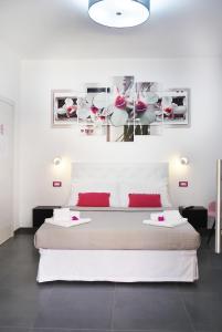 um quarto com uma grande cama branca com almofadas vermelhas em Elis b&b Villasimius em Villasimius