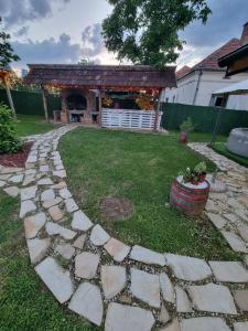 un jardín con una pasarela de piedra frente a una casa en Hacijenda Milosavljević en Vrnjačka Banja