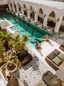 two people sitting on the floor of a swimming pool at Layla Tulum - Adults Only in Tulum