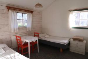 a room with two beds and a table and two chairs at Antons Gästhem in Kökar