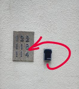 a clock on the side of a wall with a red sign at Oxfords 5 Star Lux 2 bedroom Flat near JR 4 pax, permit parking in Oxford