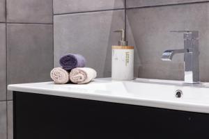 a bathroom sink with towels and a faucet at Spacieux appartement en plein Coeur de Béziers in Béziers +18 photos