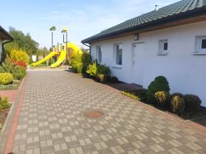um parque infantil com um escorrega amarelo ao lado de uma casa em Domki i Pokoje Baltimor em Grzybowo