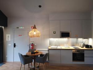a kitchen with a table and chairs and a dining room at Em Xisto - Casas de Montanha - Casa T0 in Góis