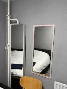 two mirrors in a room with a bed at Spacious Central London Double Room in London +11 photos