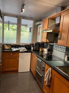 a kitchen with wooden cabinets and a stove top oven at Spacious Central London Double Room in London