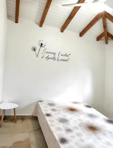 ein Schlafzimmer mit einem Bett mit einem Schild an der Wand in der Unterkunft Maison d'une chambre avec piscine privee jardin clos et wifi a Port Louis in Port-Louis