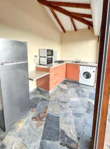 eine Küche mit einem Kühlschrank und einer Waschmaschine in der Unterkunft Maison d'une chambre avec piscine privee jardin clos et wifi a Port Louis in Port-Louis