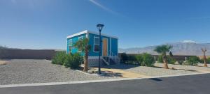 a blue house with palm trees and a street light at Paradise Tiny #3 in Desert Hot Springs