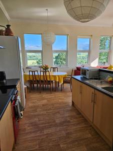 a kitchen with a table and a dining room at Old School, Spean Bridge - fun, friendly, relaxed in Spean Bridge