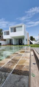 una casa con piscina frente a ella en Casa D30 Oasis Bahía Paracas en Pisco