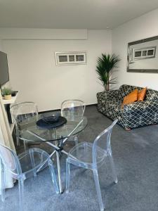 Apex Motorlodge في نيلسون: غرفة معيشة مع طاولة وكراسي وأريكة