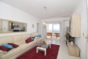 a white living room with a couch and a table at Corcyra Nigra Apartment 2 in Blato