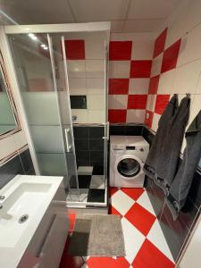 La salle de bains est pourvue d'un sol en damier rouge et blanc. dans l'établissement 3-bedroom apartment by Zako, à Bratislava
