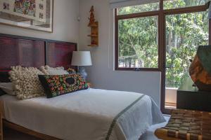 a bedroom with a white bed and a window at Casa Nawuales - Terraza - Guadalajara céntrico in Guadalajara