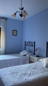 El HornilloにあるCasa San Marcosの青い壁のベッドルーム1室(ベッド2台付)